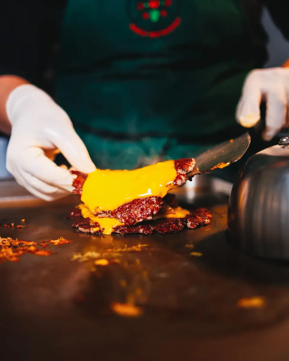 Smash burger schiacciato sulla piastra con il cheddar che cola, cucina Pizzzland Firenze